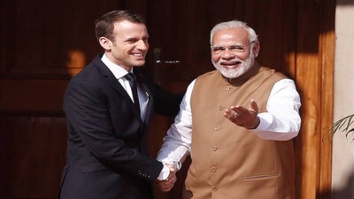 India's Prime Minister Narendra Modi shakes hands with French President Emmanuel Macron as he arrives to attend the International Solar Alliance Founding Conference in New Delhi