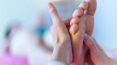 Therapist's hands massaging female foot