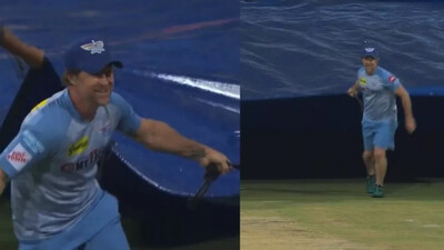 Jonty Rhodes helps ground staff cover pitch 