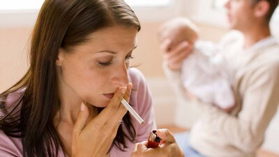 mother smoking while father soothes baby