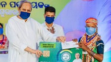 CM Naveen gives Biju Swasthya Kalyan Yojana Card to a Tribal Woman