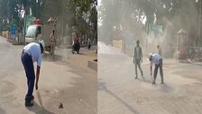 Traffic cop, Subrat Kumar Nayak sweeps accumulated  sand on road near Gandhi Chhak in Phulbani to avoid road accident